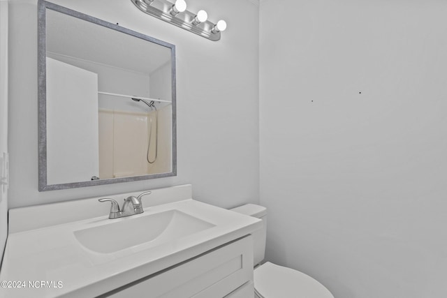 bathroom with walk in shower, vanity, and toilet