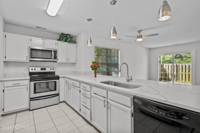 kitchen featuring white cabinets, pendant lighting, sink, and appliances with stainless steel finishes