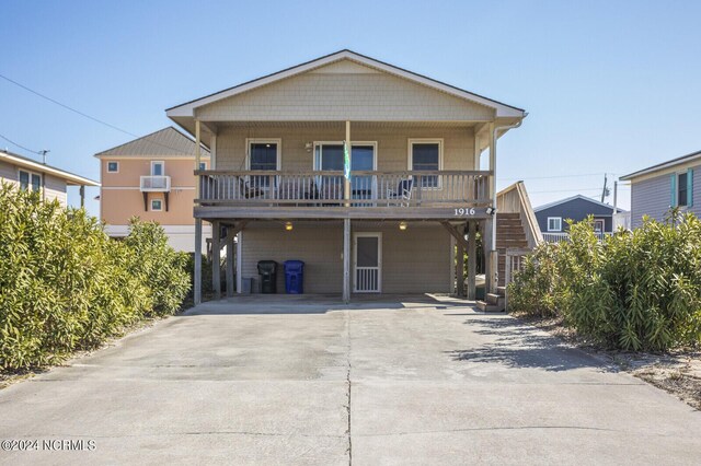 rear view of house with a porch and a carport