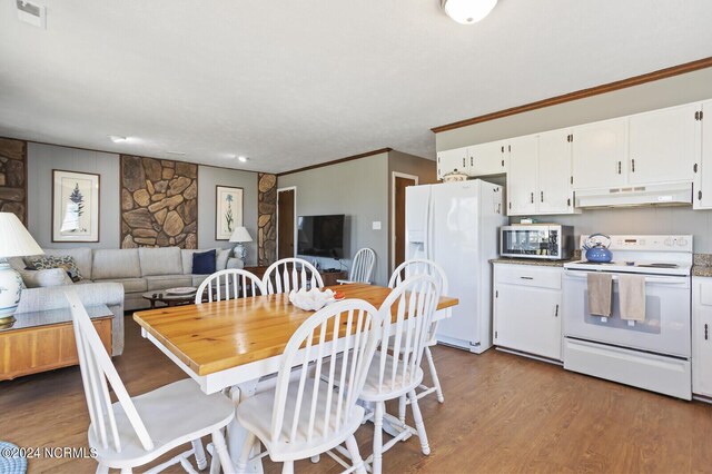 dining area featuring light hardwood / wood-style flooring and crown molding