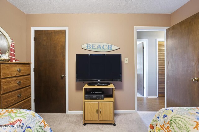 bedroom with light carpet and a textured ceiling