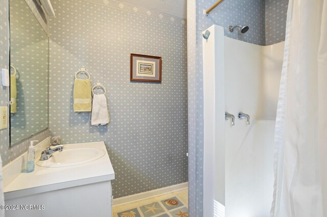 bathroom featuring a shower and vanity