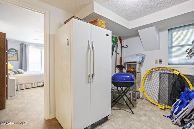 interior space featuring a textured ceiling and white fridge