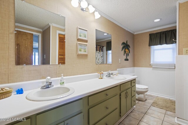 bathroom featuring vanity, tile patterned floors, toilet, ornamental molding, and a textured ceiling