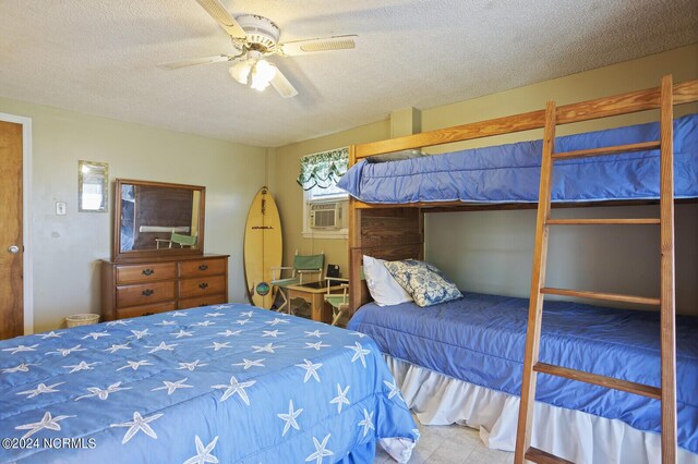 bedroom with a textured ceiling, ceiling fan, and cooling unit