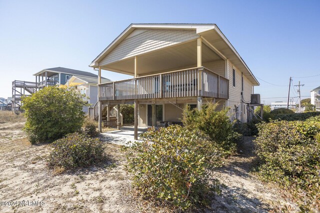 rear view of property with a patio area, a wooden deck, and central AC