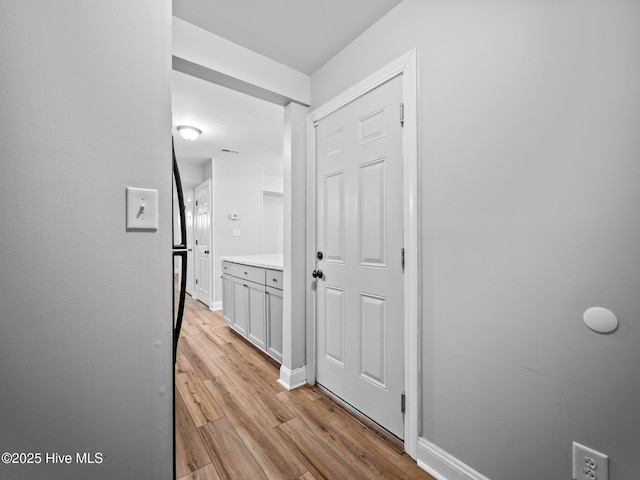 corridor with light hardwood / wood-style floors