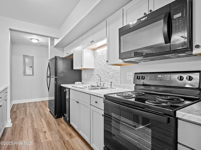 kitchen with white cabinetry, sink, and black appliances