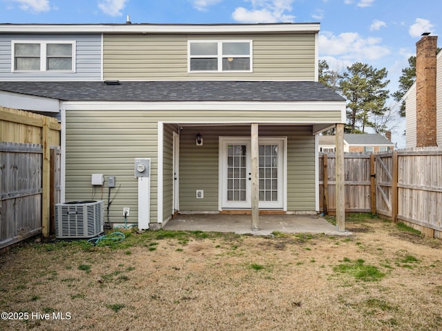 rear view of house featuring french doors, a yard, a patio area, and central air condition unit