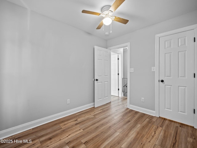 unfurnished bedroom with ceiling fan and light hardwood / wood-style flooring