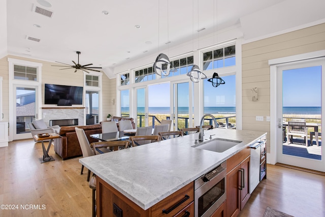 kitchen with a center island with sink, sink, and light hardwood / wood-style flooring