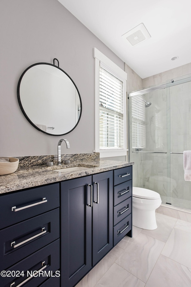 bathroom featuring tile flooring, an enclosed shower, toilet, and vanity