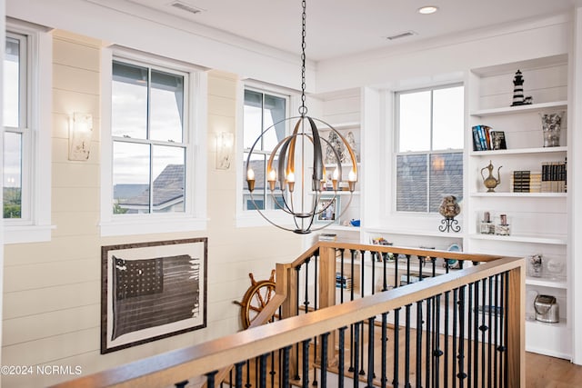 interior details with a notable chandelier, built in features, and wood-type flooring