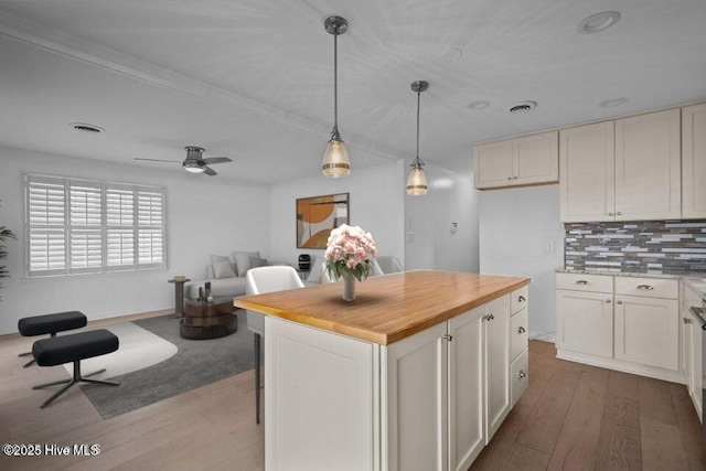 kitchen featuring decorative light fixtures, dark hardwood / wood-style floors, a center island, and white cabinets