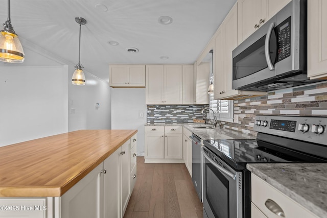 kitchen featuring tasteful backsplash, hanging light fixtures, white cabinets, and appliances with stainless steel finishes