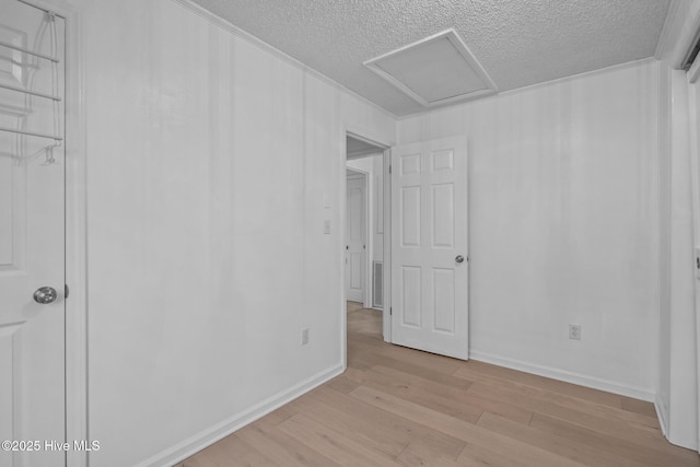 unfurnished room with light hardwood / wood-style flooring and a textured ceiling