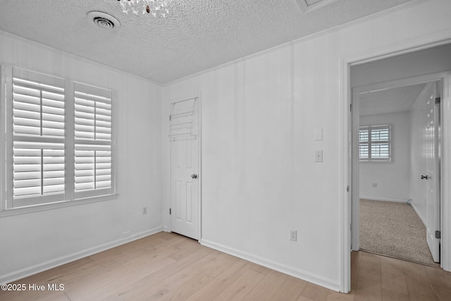 unfurnished bedroom featuring a textured ceiling and light hardwood / wood-style flooring