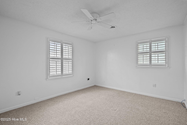 carpeted spare room with ceiling fan and a textured ceiling