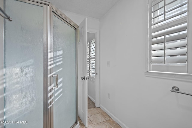 bathroom featuring ornamental molding, a shower with shower door, and tile patterned floors