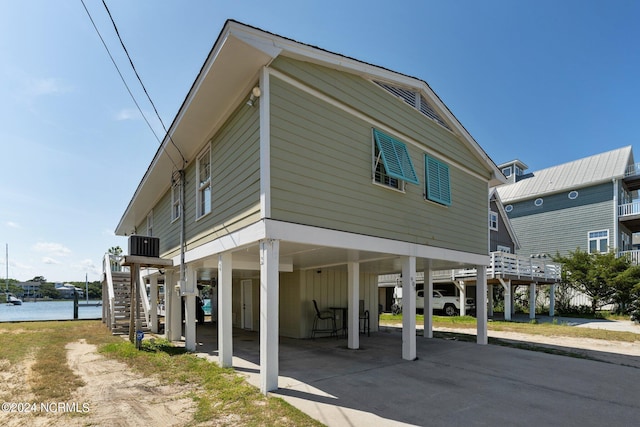 exterior space with a carport, a water view, and central AC unit