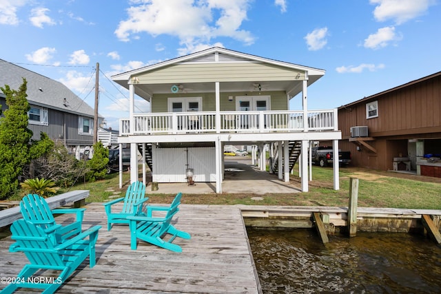 rear view of property featuring a deck with water view and a yard