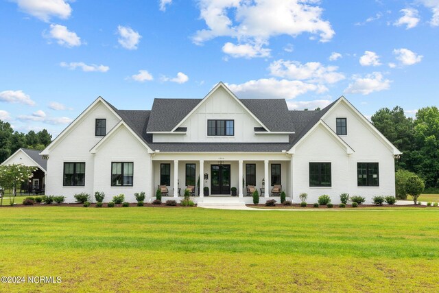 rear view of property featuring a porch and a yard