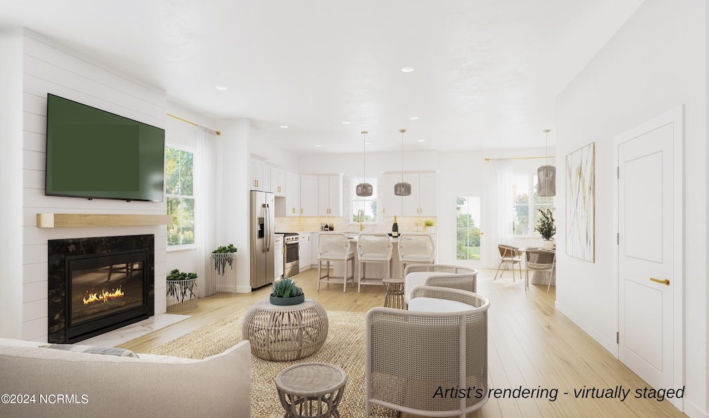 living room with light wood finished floors, a fireplace with flush hearth, and recessed lighting