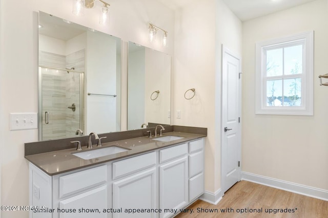 bathroom with vanity, a shower with shower door, and hardwood / wood-style floors