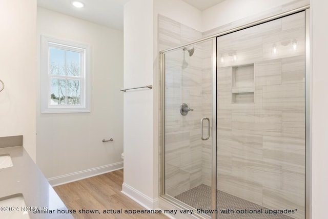 bathroom with vanity, hardwood / wood-style floors, a shower with door, and toilet