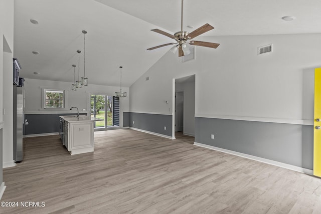 kitchen with hardwood / wood-style flooring, stainless steel fridge, an island with sink, pendant lighting, and ceiling fan