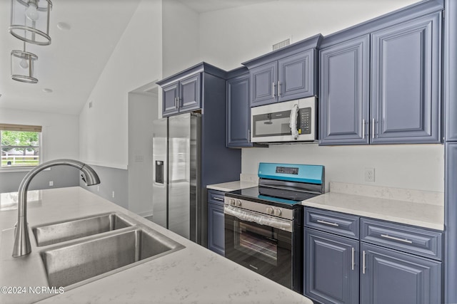 kitchen with sink, vaulted ceiling, blue cabinetry, and appliances with stainless steel finishes