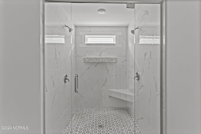 bathroom with a shower with door