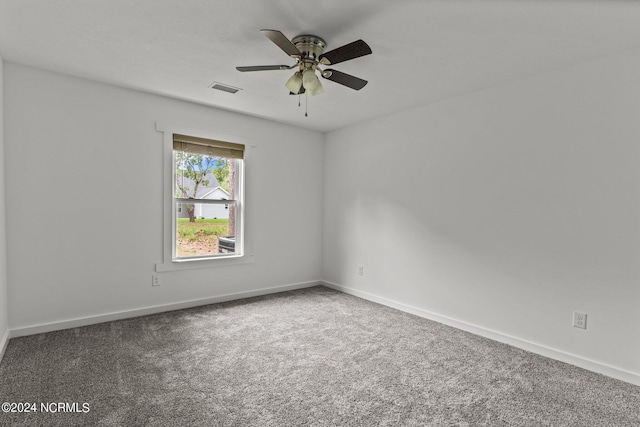 empty room with dark colored carpet and ceiling fan