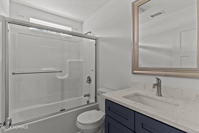 full bathroom featuring enclosed tub / shower combo, vanity, and toilet