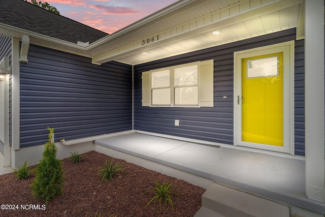 exterior entry at dusk with covered porch