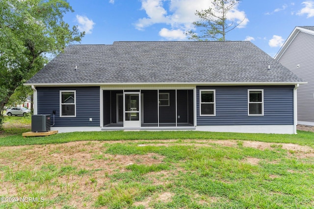 back of house featuring a lawn, a sunroom, and central air condition unit