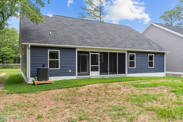 rear view of property with a sunroom, a yard, and central AC unit