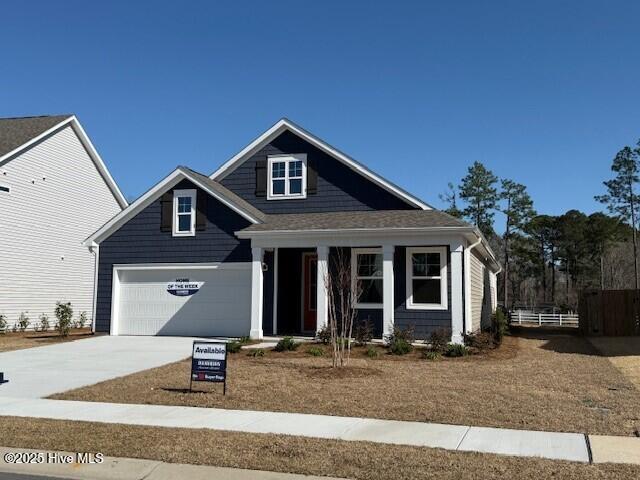 view of front facade featuring driveway, an attached garage, and fence