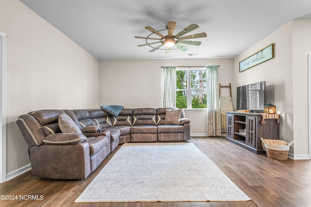 living room with wood finished floors, baseboards, and ceiling fan