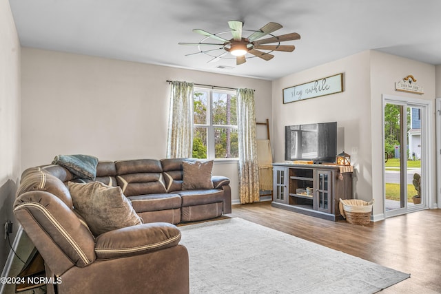 living room with visible vents, baseboards, wood finished floors, and a ceiling fan