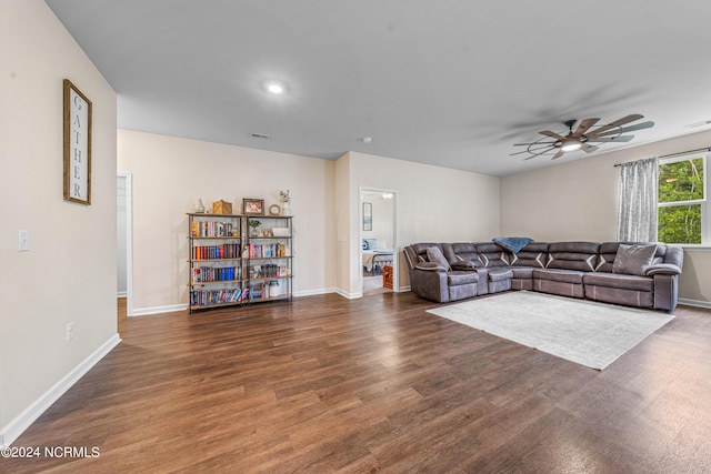 living room with wood finished floors, baseboards, and ceiling fan