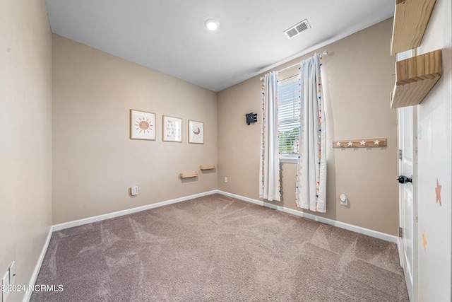 unfurnished room featuring carpet flooring, visible vents, and baseboards