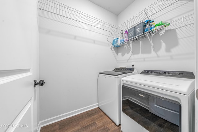 laundry area with baseboards, dark wood-type flooring, laundry area, and washing machine and clothes dryer