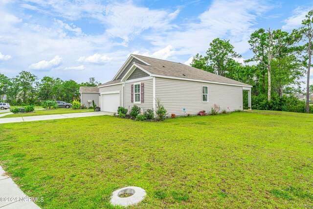 view of property exterior with an attached garage, a lawn, and driveway