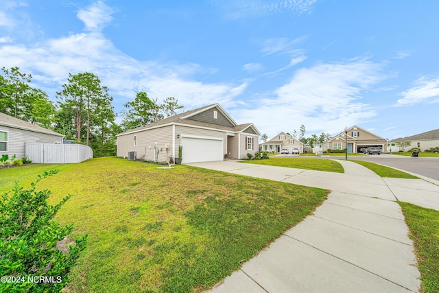 view of front facade with a front lawn, fence, concrete driveway, central AC unit, and a garage