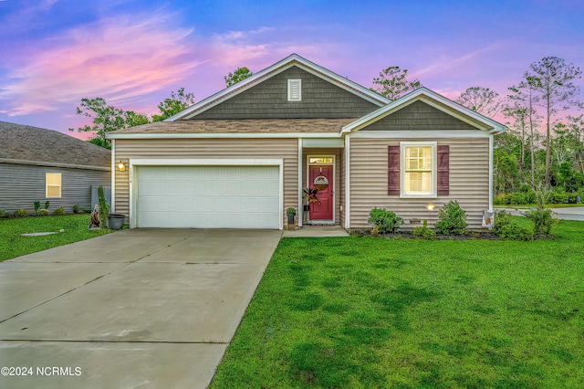 view of front of home featuring a lawn, driveway, and a garage