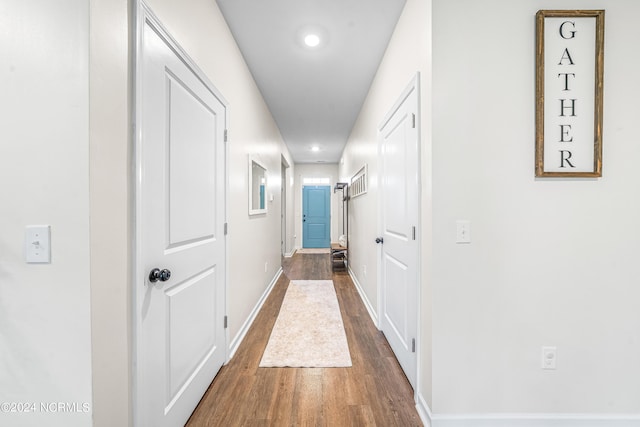 hallway featuring recessed lighting, baseboards, and dark wood-type flooring