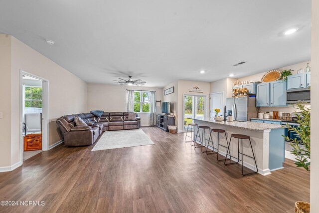 living room featuring ceiling fan and dark hardwood / wood-style flooring