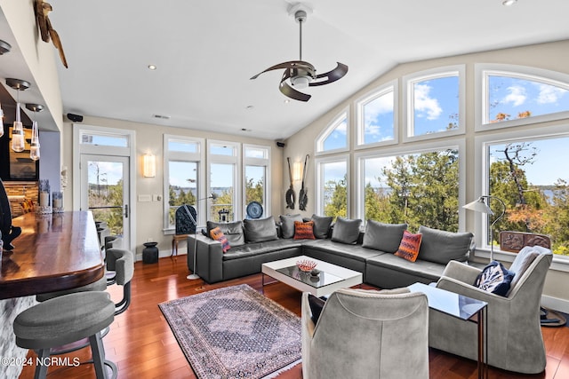 living room featuring ceiling fan, plenty of natural light, wood-type flooring, and vaulted ceiling