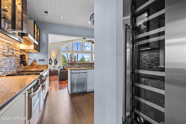 kitchen featuring decorative backsplash, stainless steel appliances, wooden ceiling, white cabinets, and wine cooler